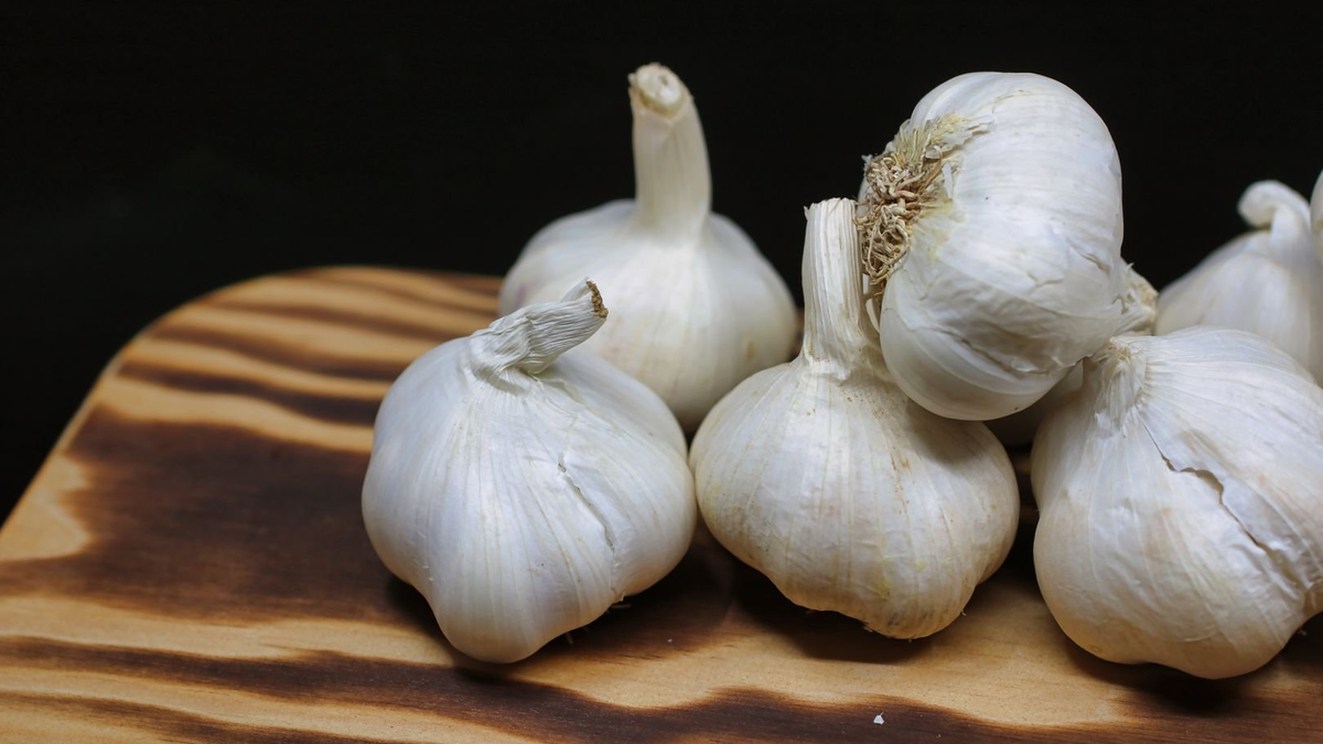 Whole garlic bulbs on a wooden board
