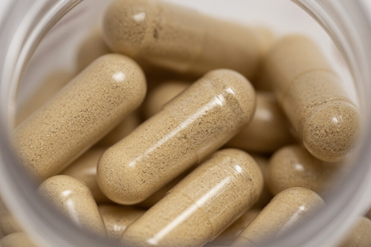 Close-up of beige capsules in a clear container